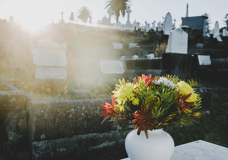 cementerio con un ramo de flores en el centro de una tumba